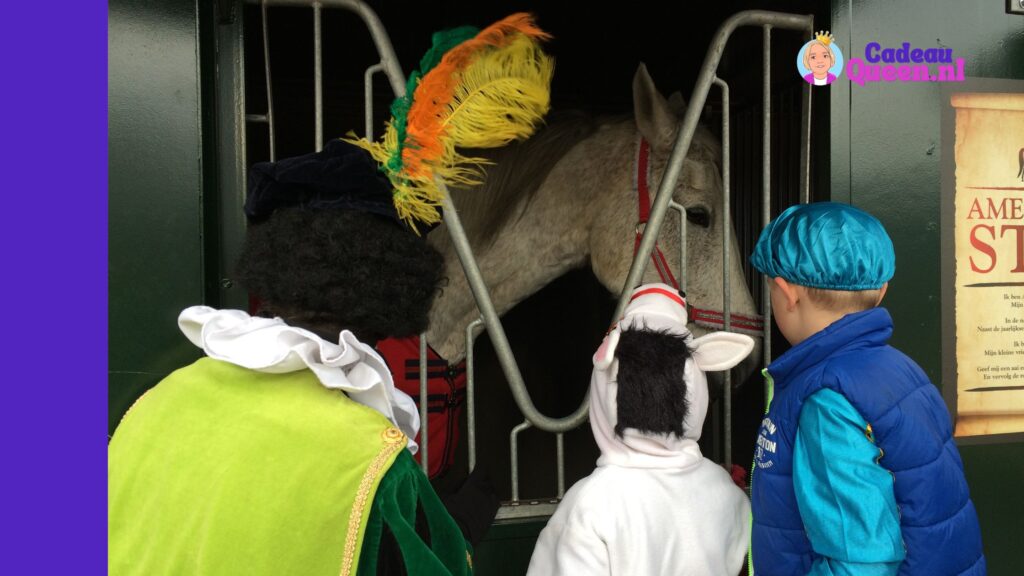 Kinderen voeren het paard van Sinterklaas een wortel