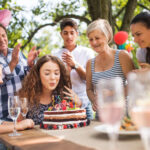 Familie viert verjaardag buiten met taart en kaarsen