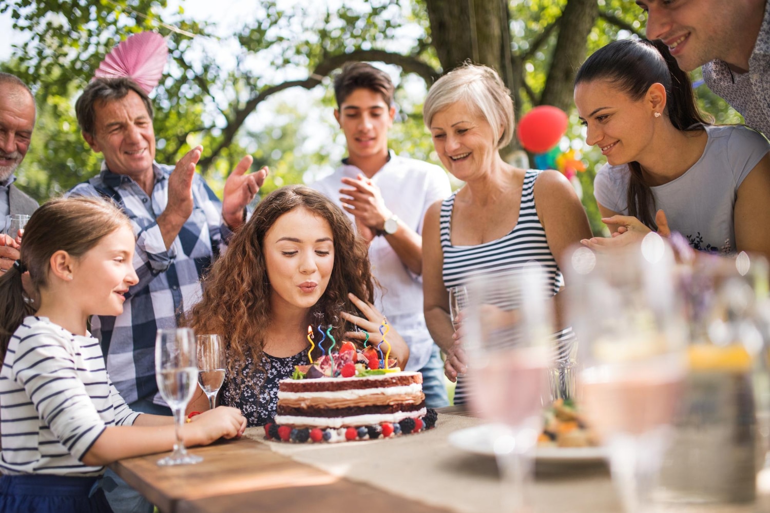 Familie viert verjaardag buiten met taart en kaarsen